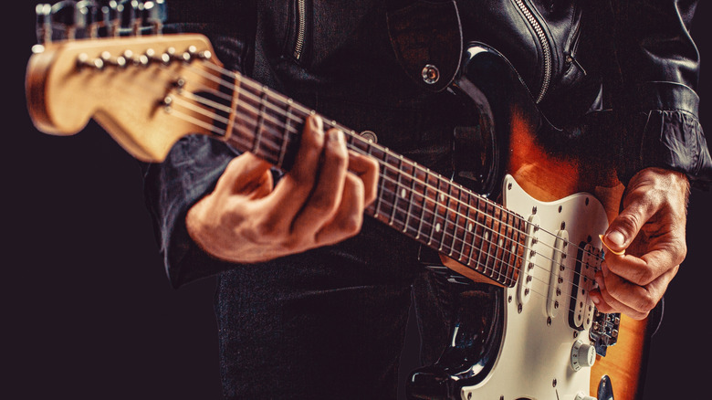 A close-up shot of someone playing an electric guitar.