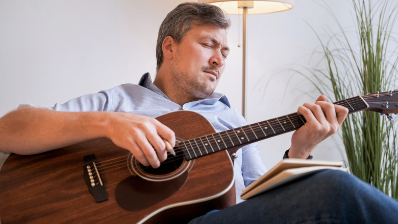 Guy practicing acoustic guitar