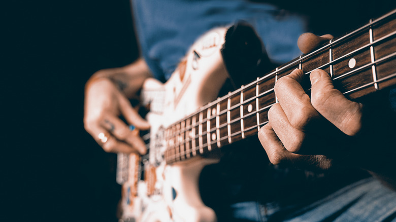 Person plucking bass strings