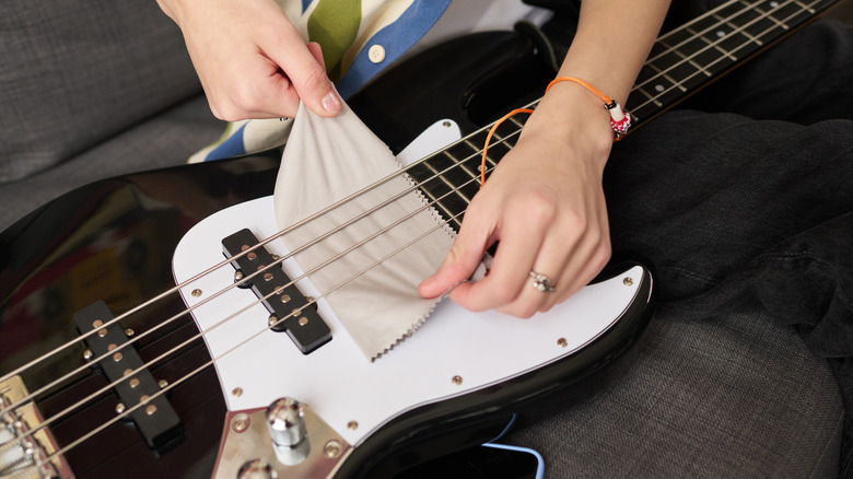 Person cleaning electric guitar