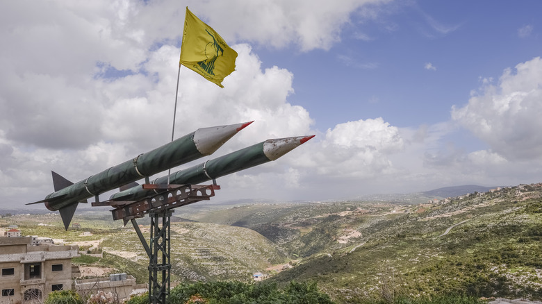 Hezbollah flag flying over missiles