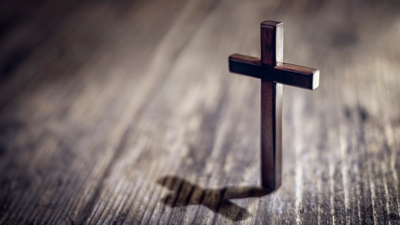 Cross on plain wooden background