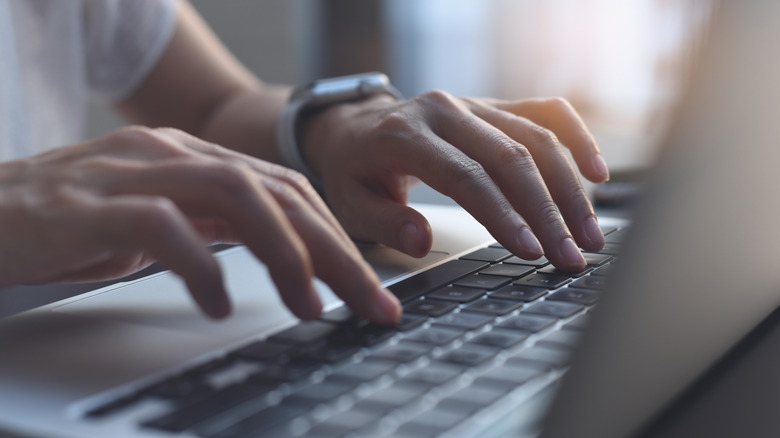 fingers typing on a keyboard