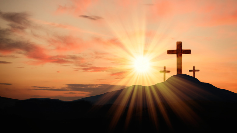 Three crosses on hill sunset