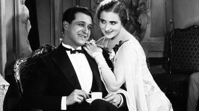 A wealthy 1920s couple sitting at home