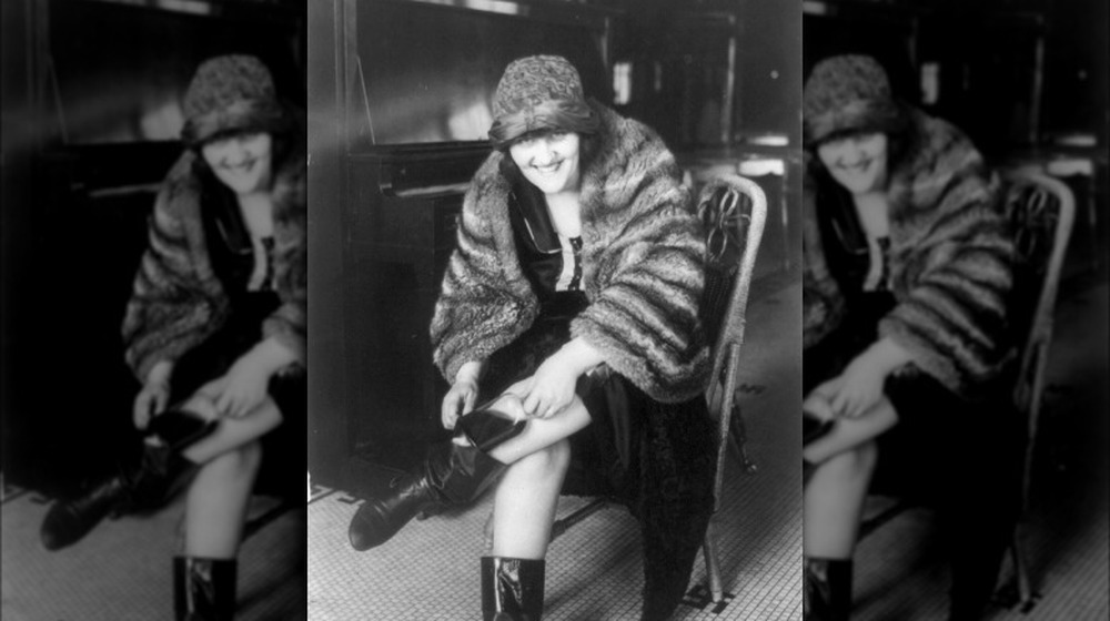 Woman putting flask in her Russian boot