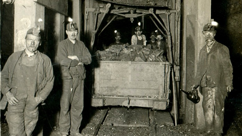miners standing with coal car