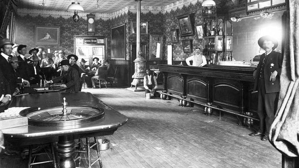 bar with Roulette wheel and men gambling 