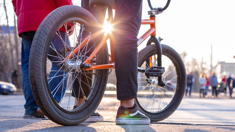 teen on bike with sun setting