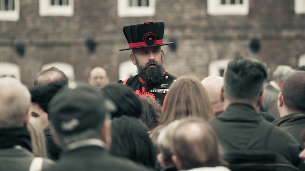 beefeater tour guide among group of tourists