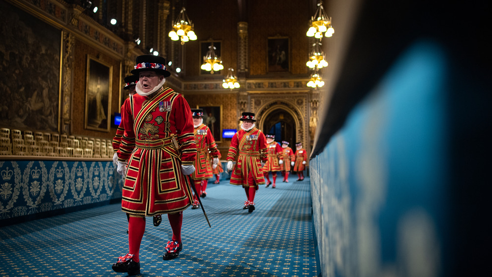 beefeater in tudor dress walking down hall