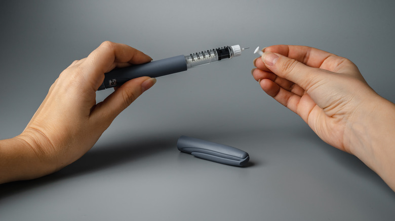 woman holding a syringe for insulin