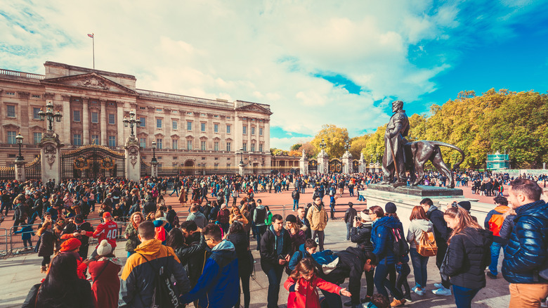 Tourists crowd front of Buckingham Palace