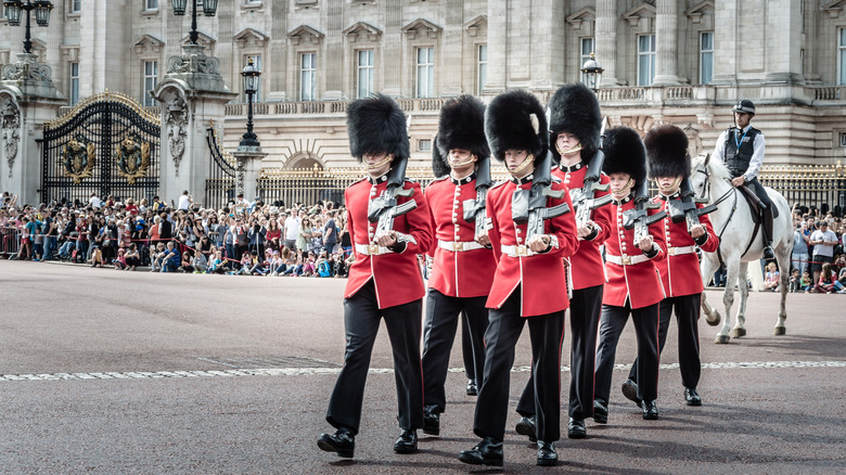 Guardsmen in red uniforms marching outside Palace