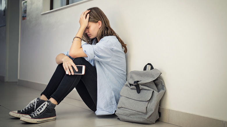 Sad woman sitting in hallway