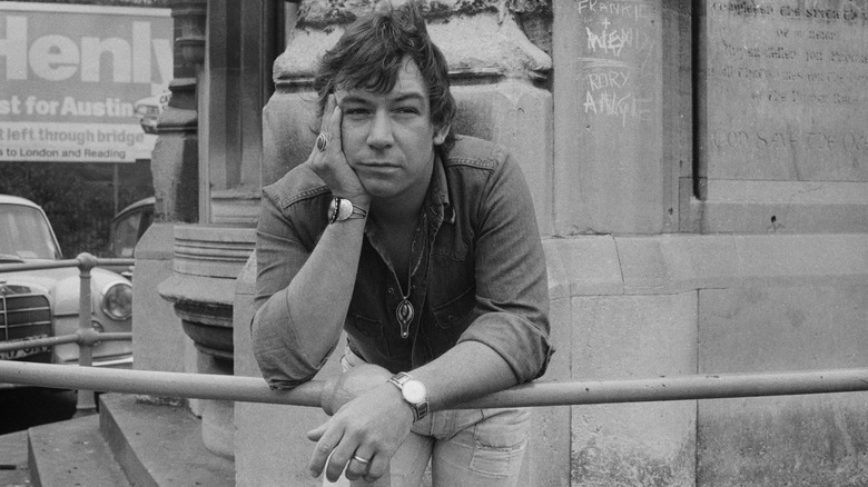 Eric Burdon leaning on a fence