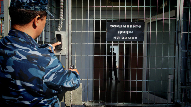 prison guard in front of Russian jail cell