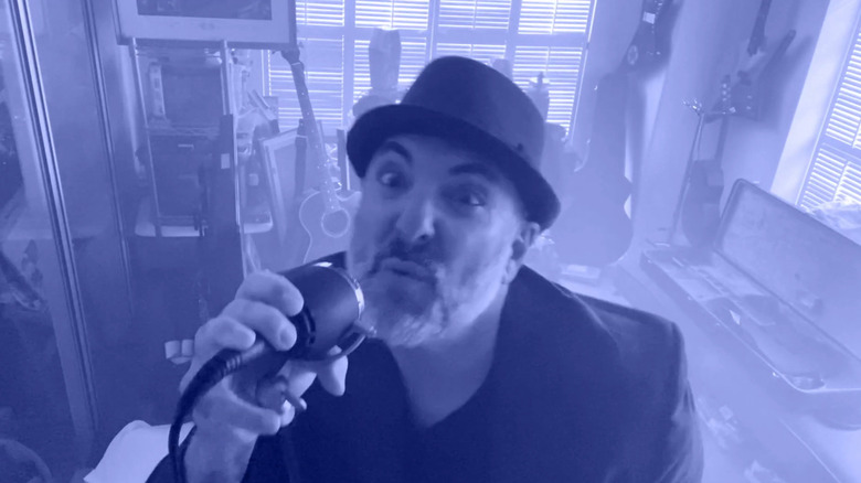 Brian Tutunick singing in music video wearing small black hat