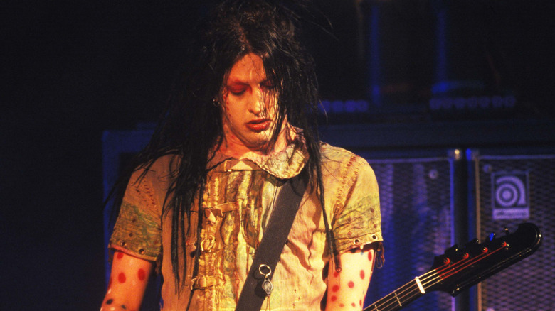 Twiggy Ramirez playing bass on stage with long hair