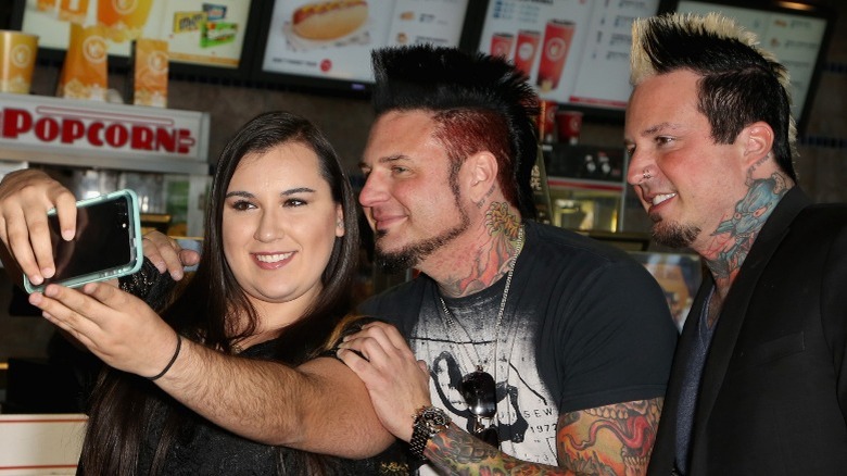 A fan takes a picture with members of Five Finger Death Punch in 2017