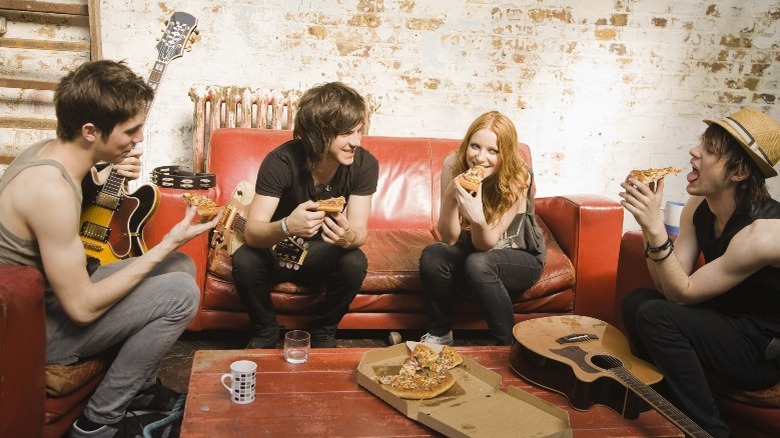 Group of musicians eating pizza