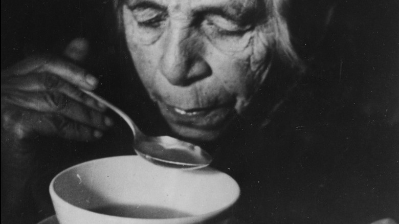 Old Jewish woman drinks soup