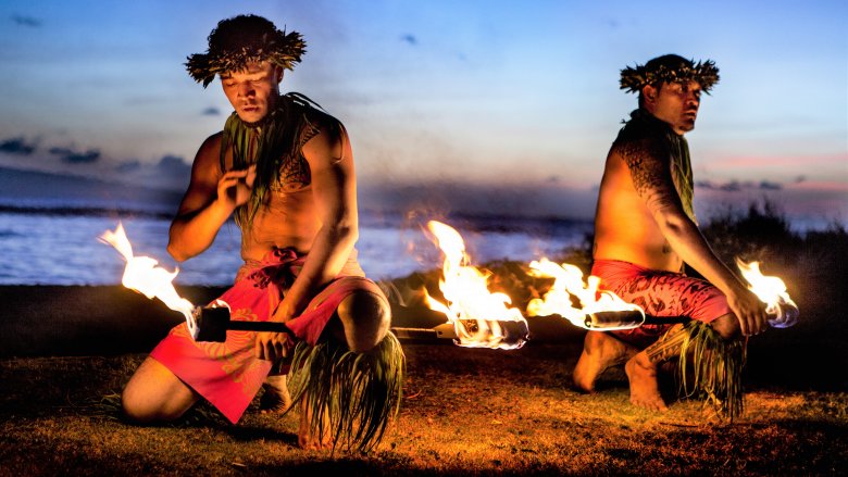 Hawaiian men prepare to swallow fire in Maui