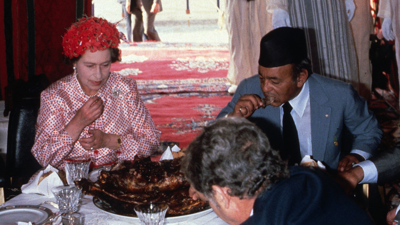 Queen Elizabeth eating with guests