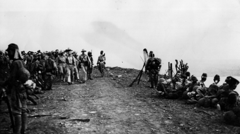 POWs lined walking and sitting