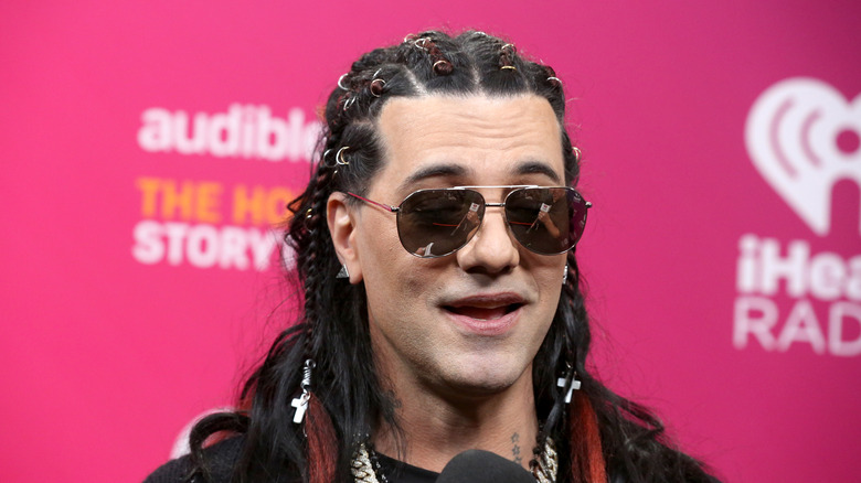 Criss Angel wearing sunglasses and looking upward