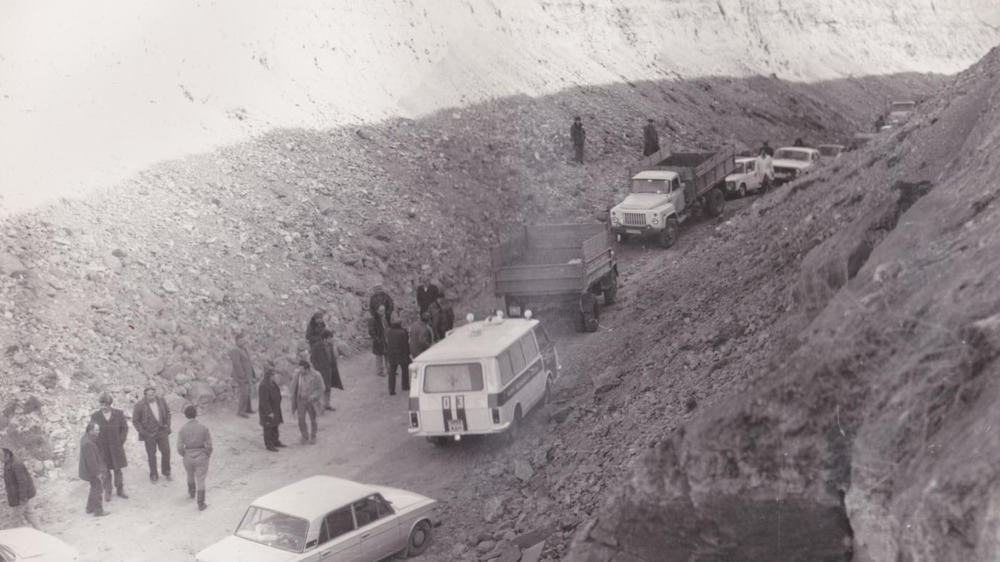 Thin road crowded with cars and people due to landslide