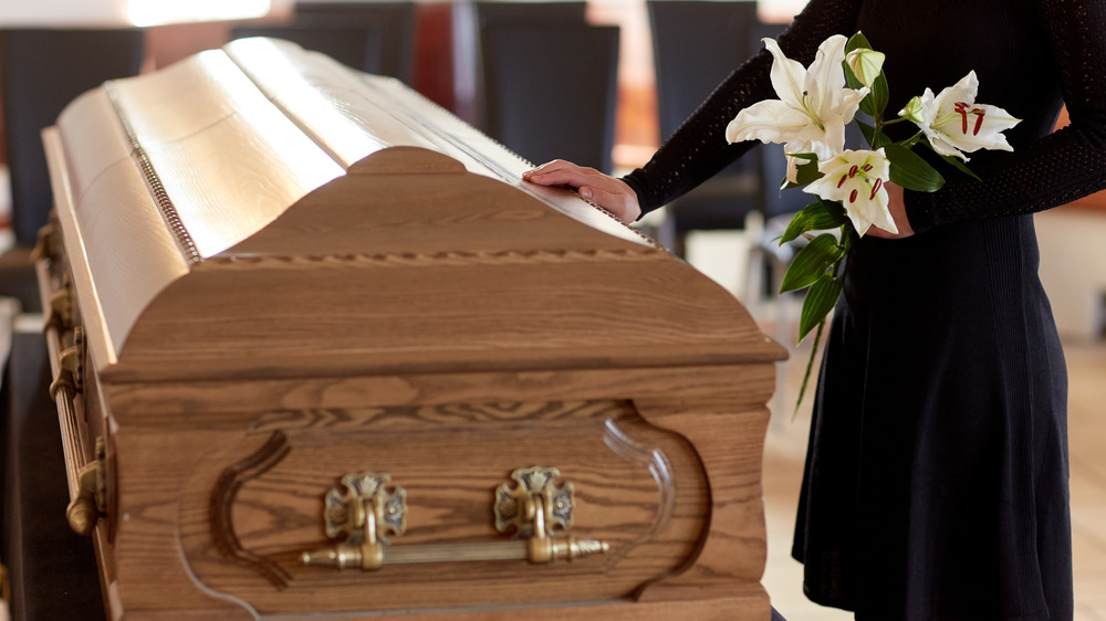 Casket and person with flowers