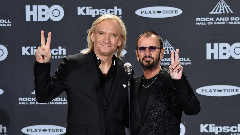 Joe Walsh posing with Ringo Starr, both dressed in black