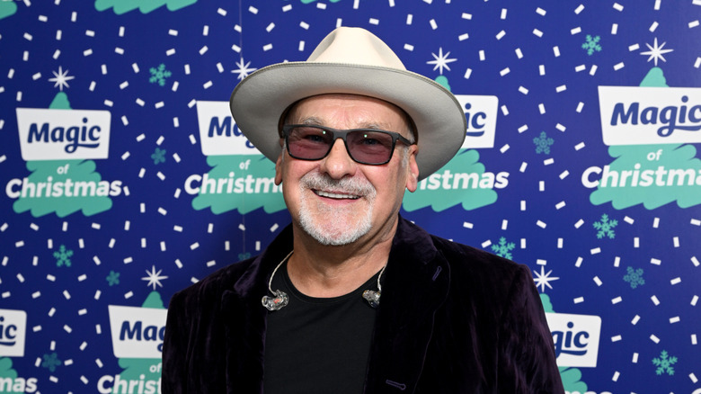 Paul Carrack wearing a white hat while posing on the red carpet during Christmas event