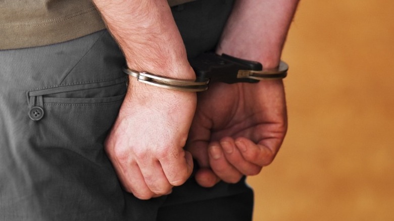 man's hands in handcuffs behind back