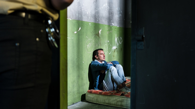 Man sitting on a cell mattress