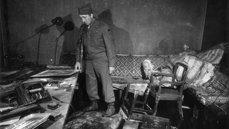 A serviceman looking at the room in the Führerbunker where Hitler and Eva Braun died