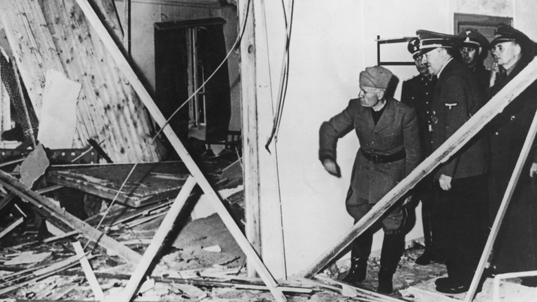 Adolf Hitler showing Benito Mussolini where his assassination attempt occured