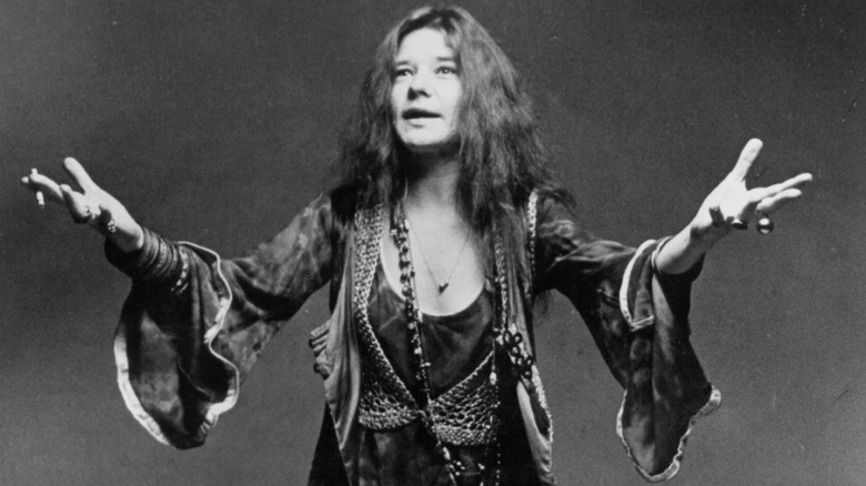 Janis Joplin posing with her arms wide for a publicity shot