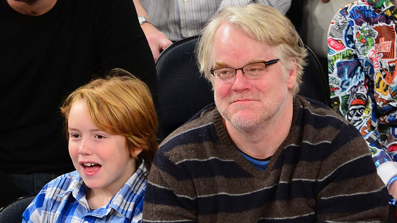 Philip Seymour Hoffman and Cooper Hoffman sitting courtside at basketball game