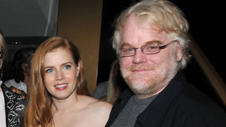 Amy Adams standing with Philip Seymour Hoffman