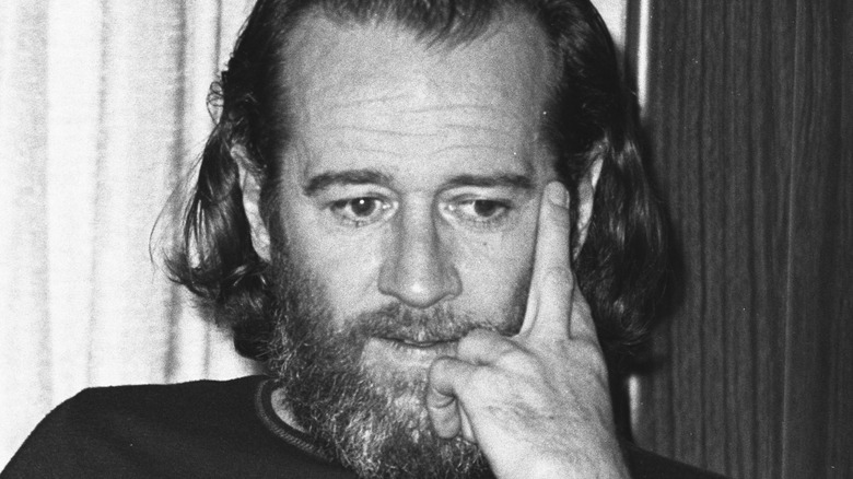 George Carlin fingers on cheek