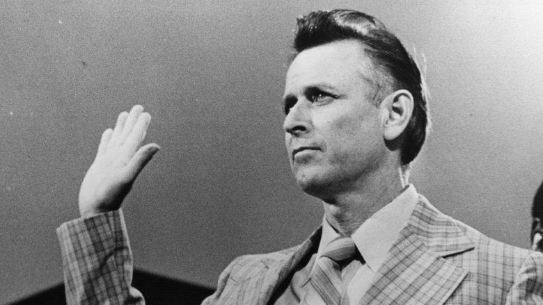 James Earl Ray raised hand in a chequered suit