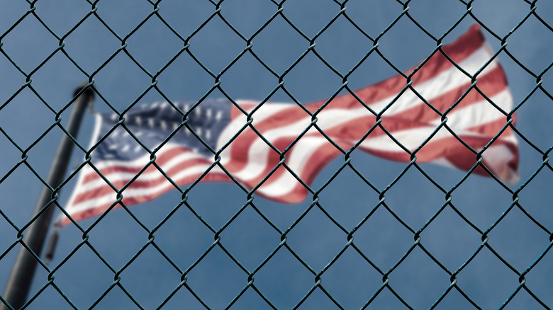 American flag behind a prison fence
