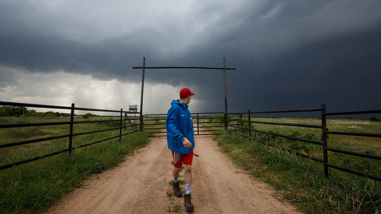 Man walking away from supercell storm