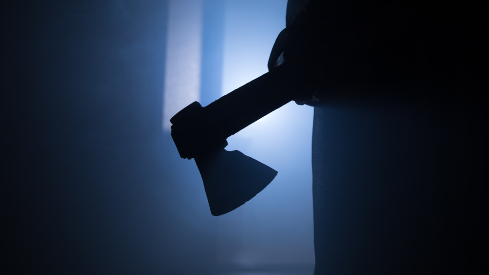 Sillhouette of figure holding ax