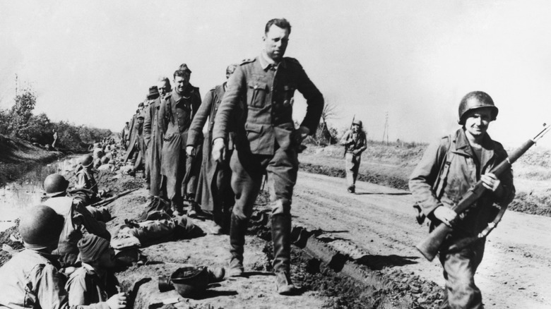 captured Nazi POWs forced to march outside by trenches