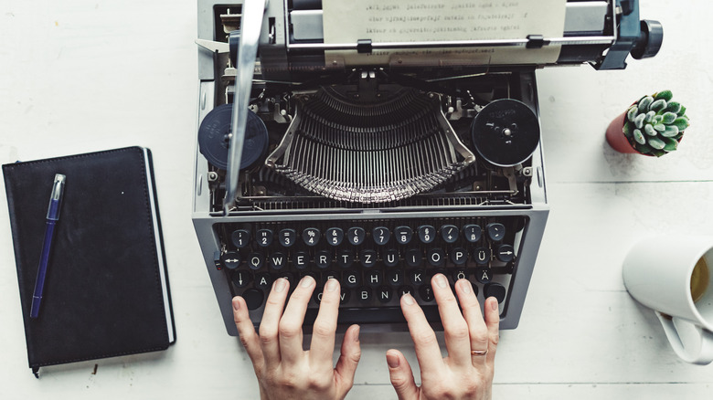 hands on an old typewriter 