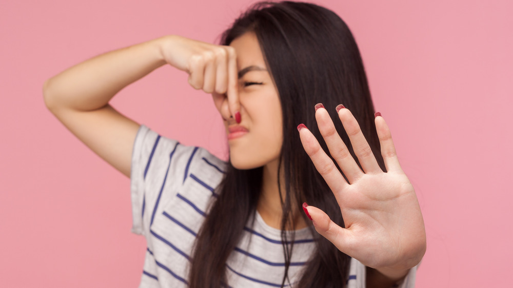 Disgusted woman holding her nose