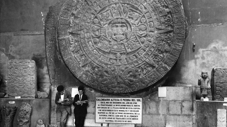 people standing in front of the Aztec Sun Stone